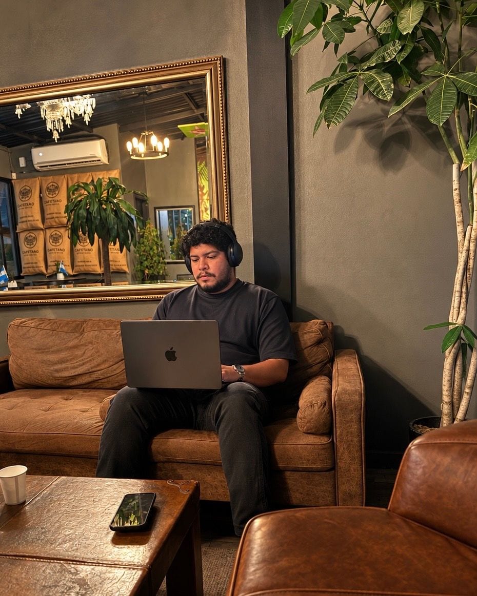 Eduardo S. Acosta, founder of Teikof, working on a laptop in a café in Tegucigalpa